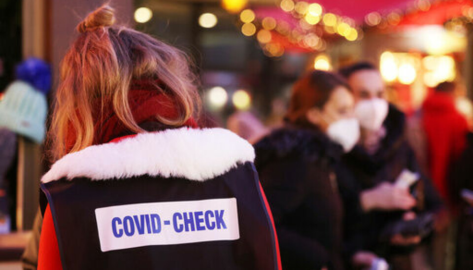 En inspektør går gjennom julemarkedet i Köln for å sjekke at alle som er til stede er vaksinert eller har hatt covid-19. Foto: Oliver Berg/dpa via AP/NTB
