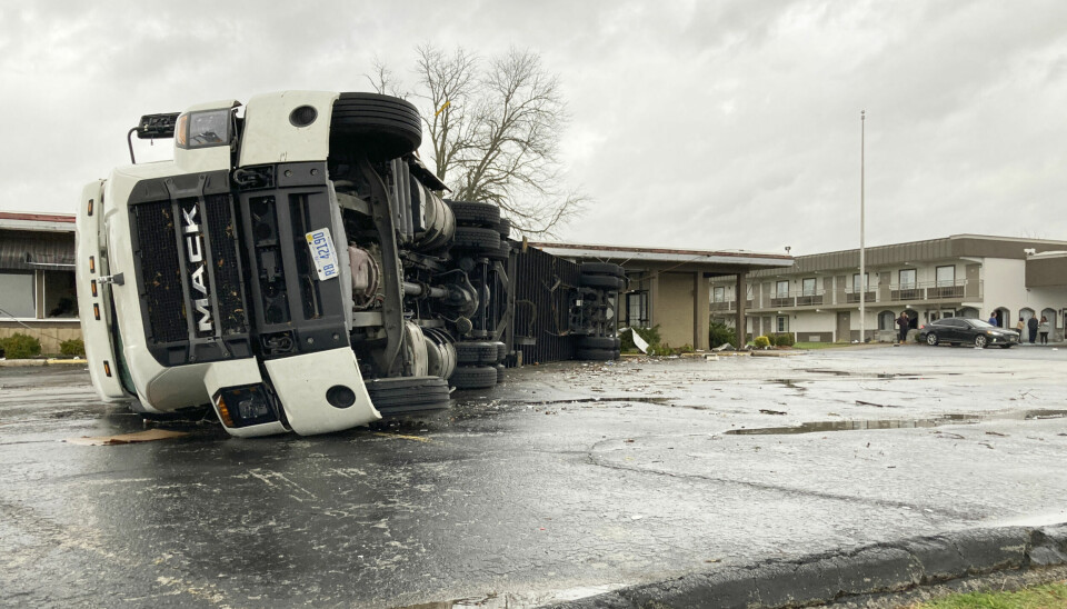 A large semi trailer is flipped over and pushed against a building in Bowling Green, Ky., on Saturday, Dec. 11, 2021. Tornadoes and severe weather caused catastrophic damage across multiple states late Friday, killing at least six people overnight as a storm system tore through a candle factory in Kentucky, an Amazon facility in Illinois and a nursing home in Arkansas. (AP Photo/Dylan T. Lovan)