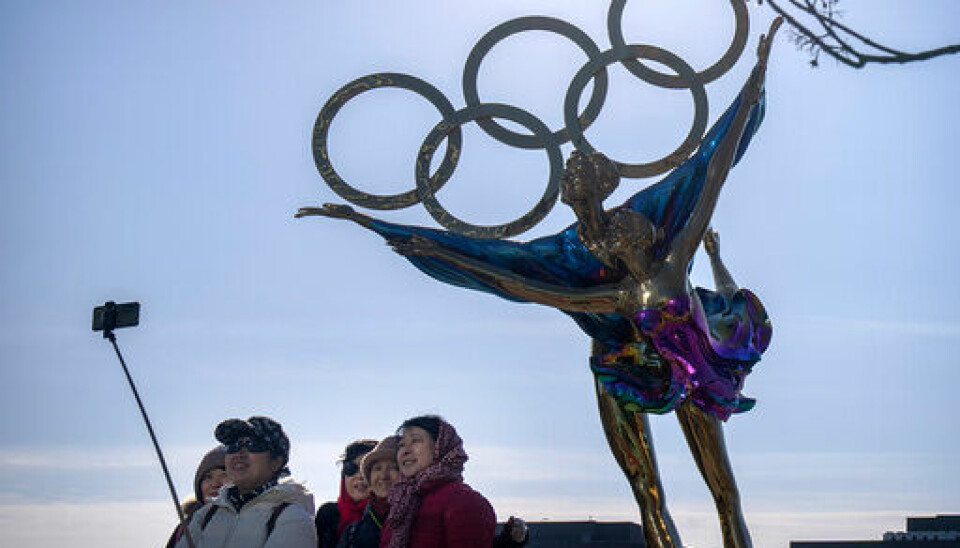 Folk tar selfie foran en statue med de berømte OL-ringene i Beijing. Foto: Mark Schiefelbein / AP / NTB
