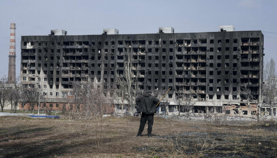 A man looks at a burned apartment building that was damaged by shelling in Mariupol, Ukraine, Sunday, March 13, 2022. (AP Photo/Evgeniy Maloletka)